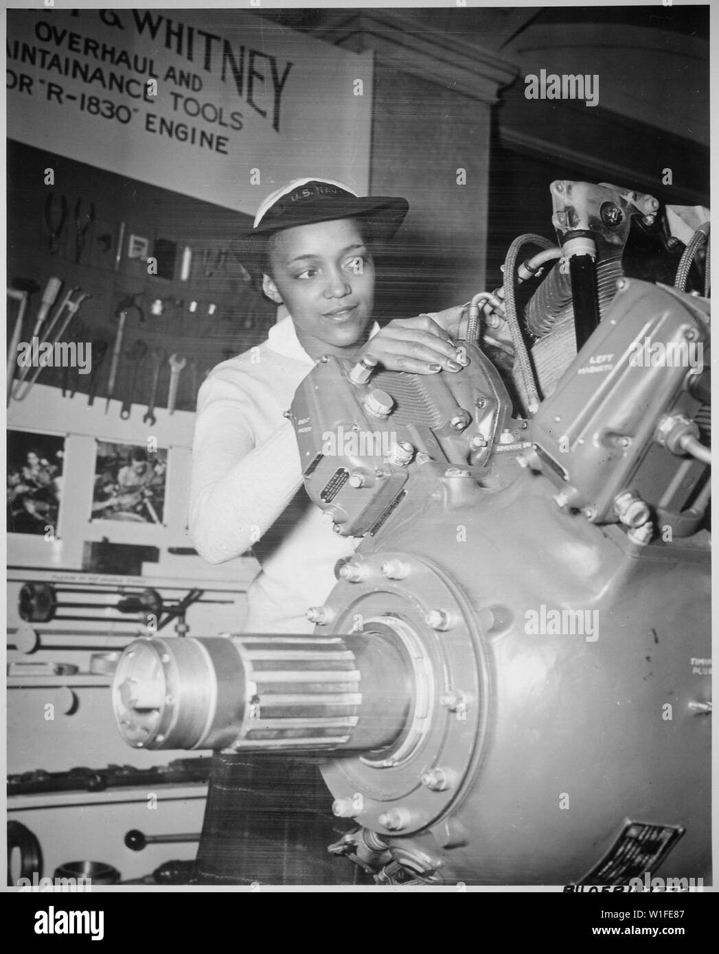 Inspecting a Grumman Wildcat engine on display at the U.S. Naval Training School (WR) Bronx, NY, where she is a `boot' is WAVE Apprentice Seaman Frances Bates., 1945 Stock Photo